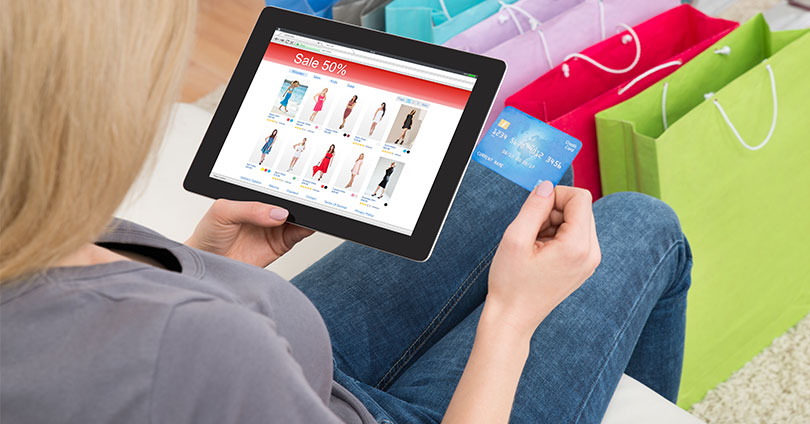 Perfil do consumidor. Mulher comprando roupa com cartao de credito pelo tablet