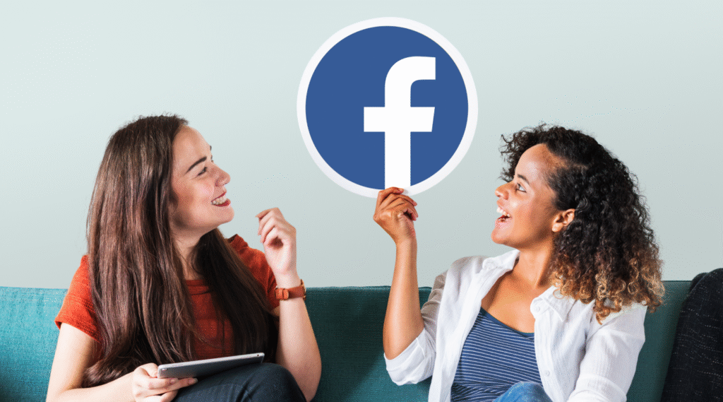 Mulheres sentadas em um sofá e olhando para o logotipo do facebook