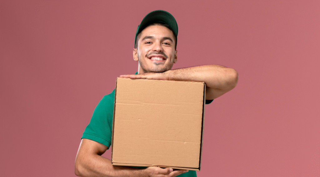 Entregador sorrindo e segurando uma caixa de entrega com as duas mãos